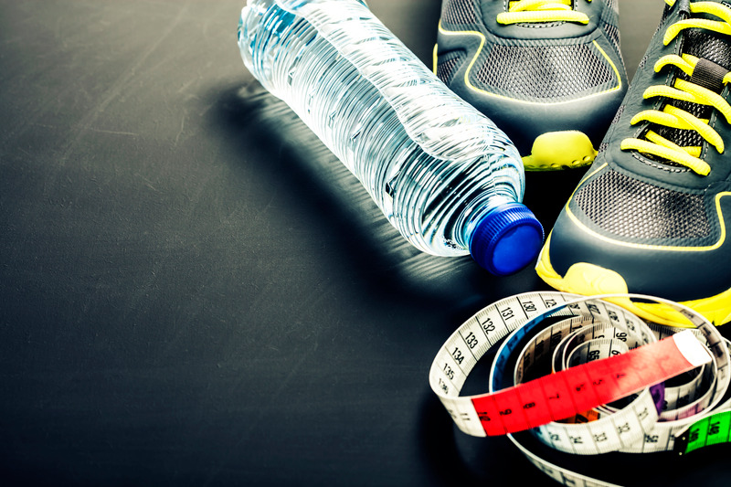 Sport shoes, measuring tape and water